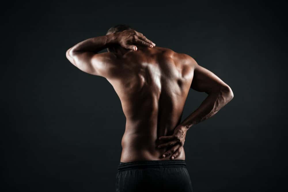 back view of young african sports man feeling pain in his back