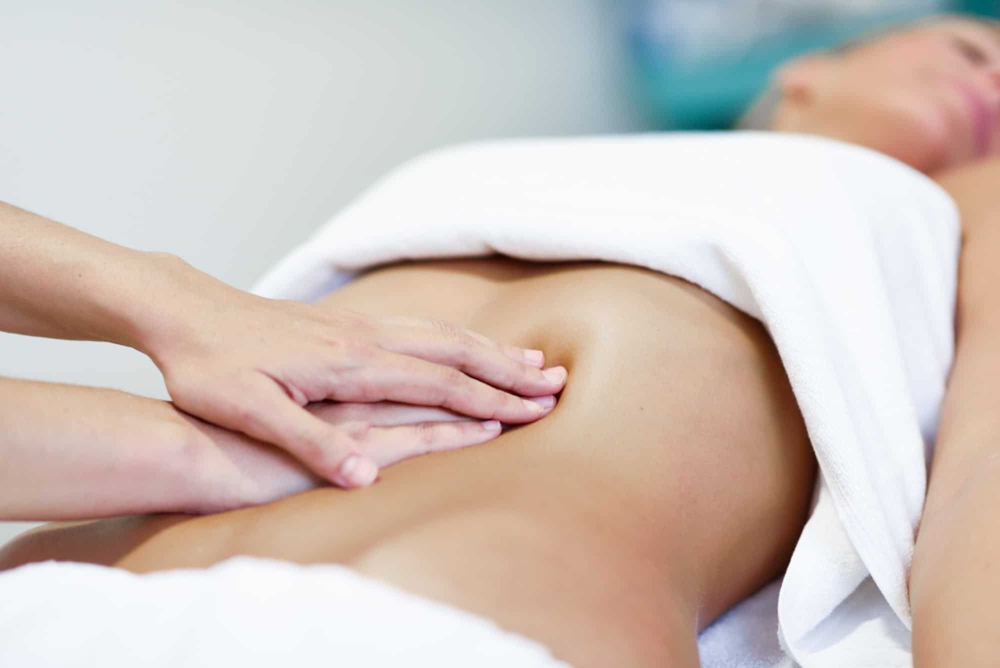 hands massaging female abdomen therapist applying pressure on belly
