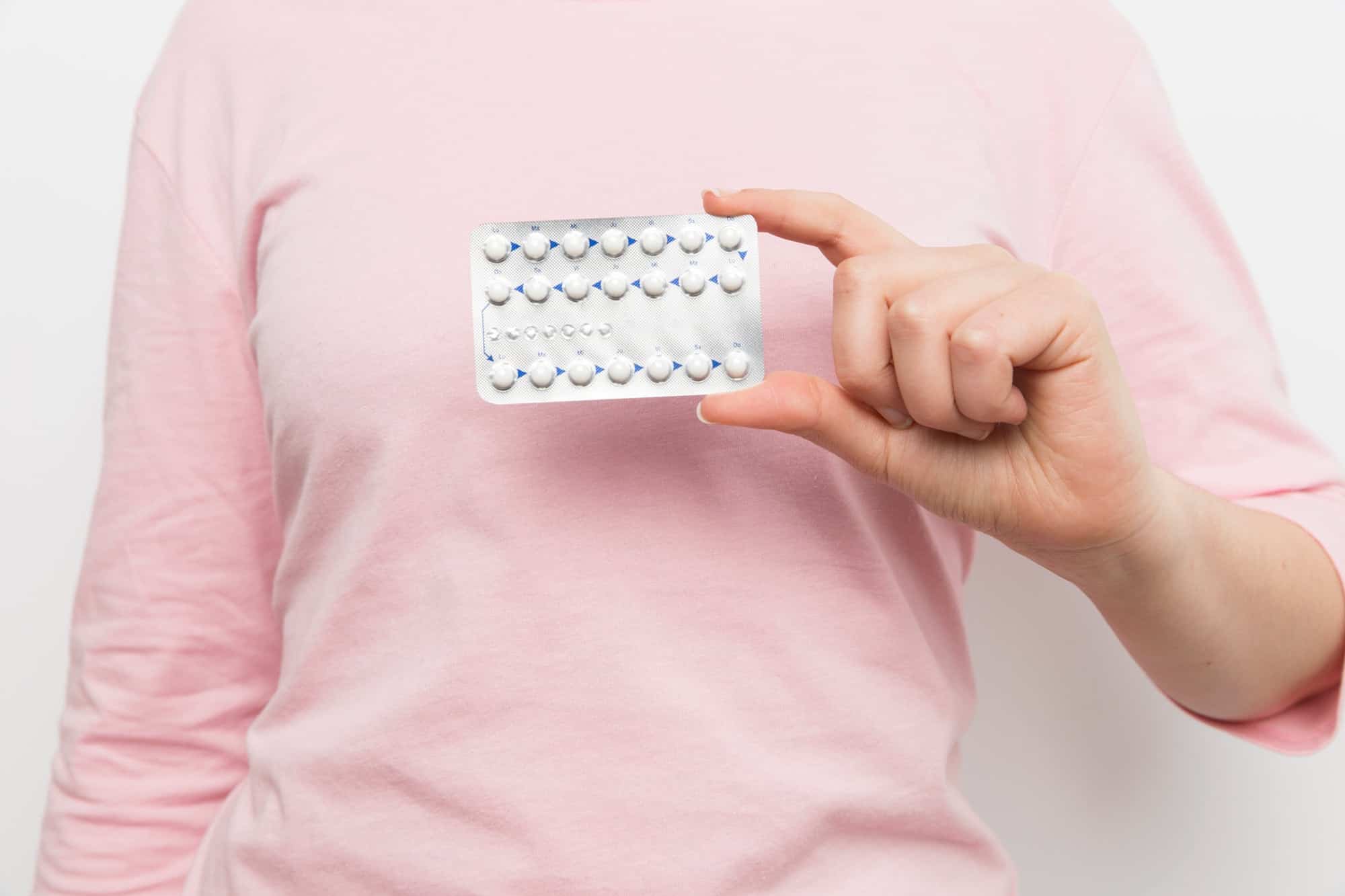 woman holding contraceptive pills